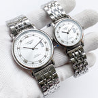 Longines watch with silver metal bracelet, white dial, Roman numerals and date window.