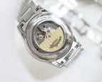 Longines wristwatch caseback with exposed mechanical movement inside silver bezel