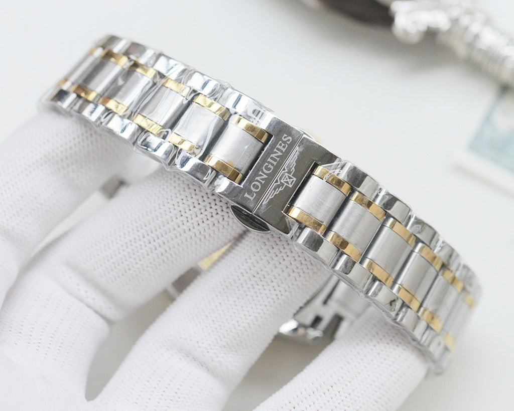 Two-tone Longines metal bracelet watch with gold accents on a linked steel strap