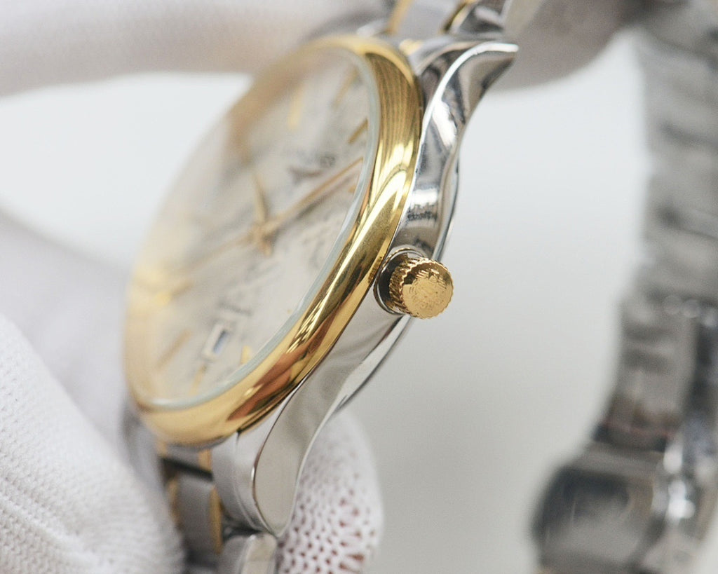 Longines wristwatch with polished silver case and gold-tone crown, side profile