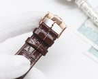 Brown leather watch strap with metal buckle and stitched edge