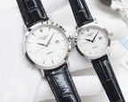 Silver analog wristwatch pair with white dials and black leather straps