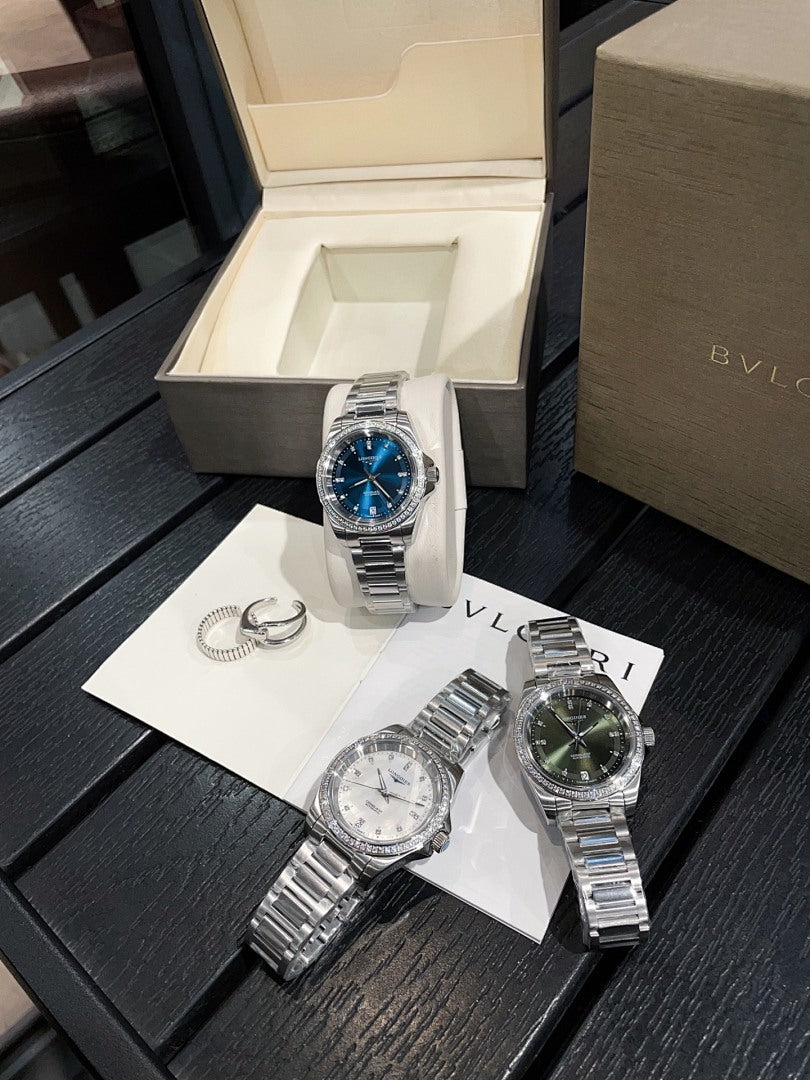 Stainless steel wristwatch on display stand with blue dial and metal bracelet