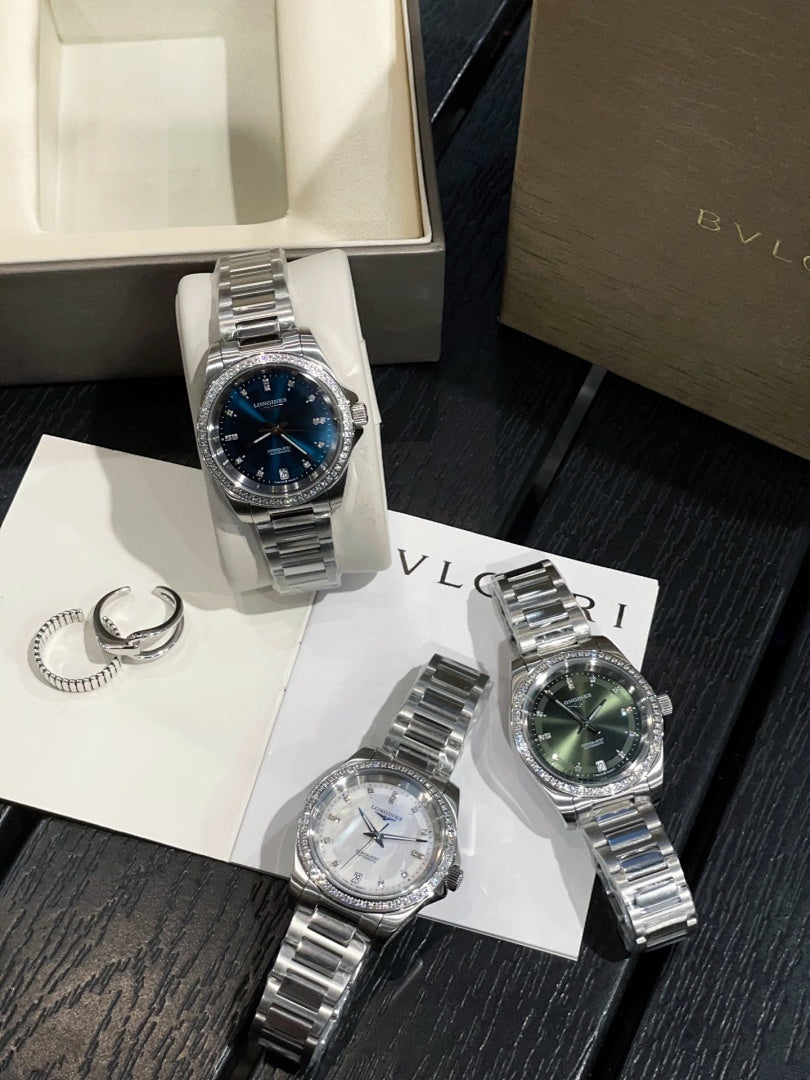 Stainless steel wristwatch with blue dial and metal bracelet on white cushion