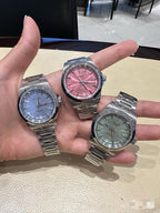 Longines wristwatch set with silver metal bracelets: blue, pink, and green dials.
