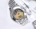 Longines watch case back with exposed movement and silver link bracelet