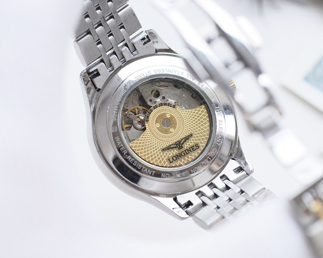 Longines watch case back with exposed movement and silver link bracelet
