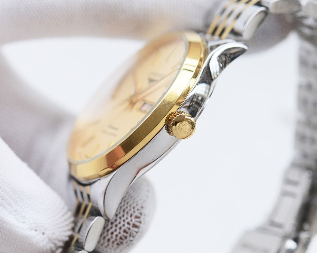 Two-tone Longines watch with gold-tone bezel and silver case, visible crown