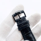 Black leather watch strap with metal buckle clasp and stitched edges