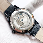 Back of mechanical watch with round stainless case and black leather strap