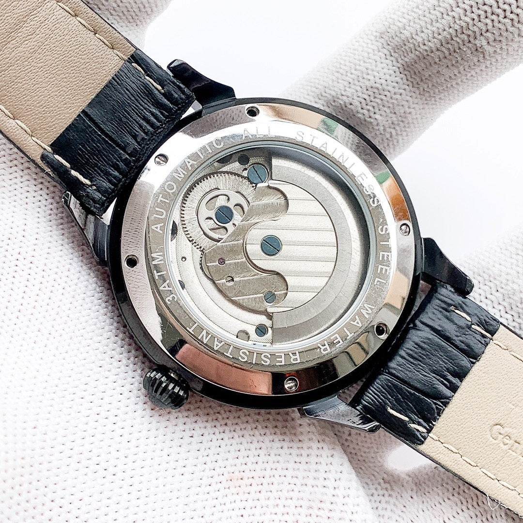 Back of mechanical watch with round stainless case and black leather strap