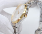 Longines wristwatch with gold-toned crown and side profile on a metal bracelet.