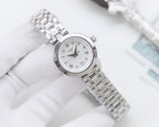 Silver Longines watch with white dial and metal mesh bracelet, angled view