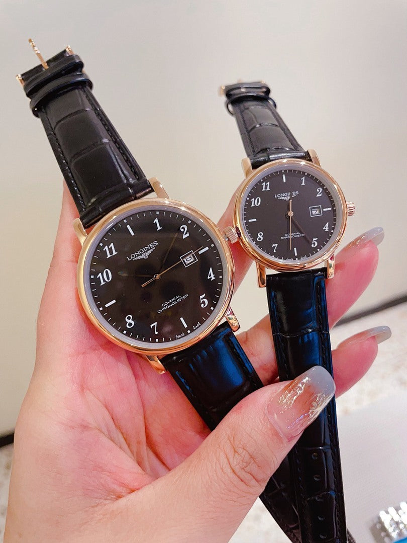 Pair of Longines watches with dark and white dials, dark leather straps, gold-tone cases.