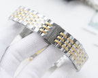 Longines metal bracelet wristwatch with two-tone gold accents and clasp on wrist.
