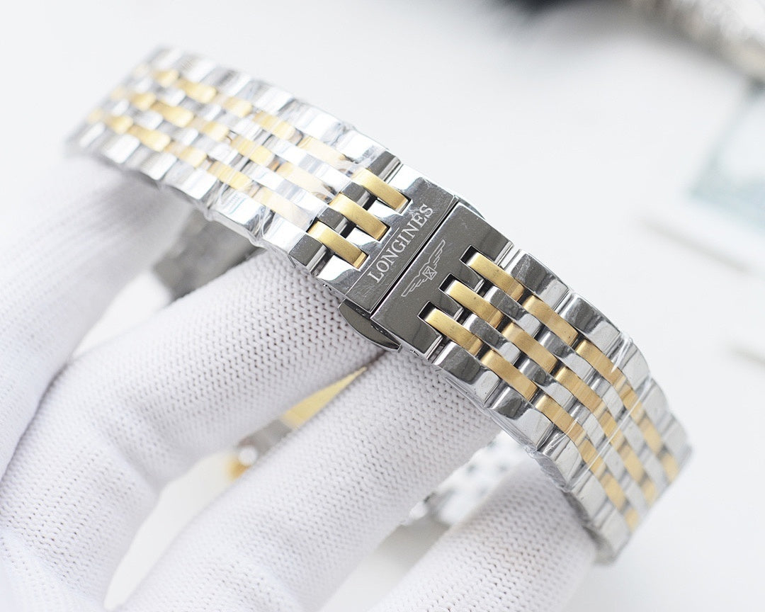 Longines metal bracelet wristwatch with two-tone gold accents and clasp on wrist.