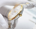 Longines gold-tone bezel wristwatch on wrist with white dial and crown detail.