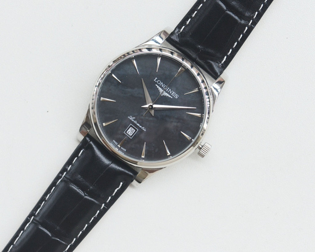 Longines wrist watch with silver-tone case, dark dial, black leather strap.