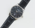 Longines wrist watch with silver-tone case, dark dial, black leather strap.