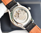 Automatic wristwatch caseback, silver movement view, orange leather strap, round screw-in back