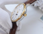 Analog wristwatch, brown leather strap, gold-tone crown and case, partial dial view