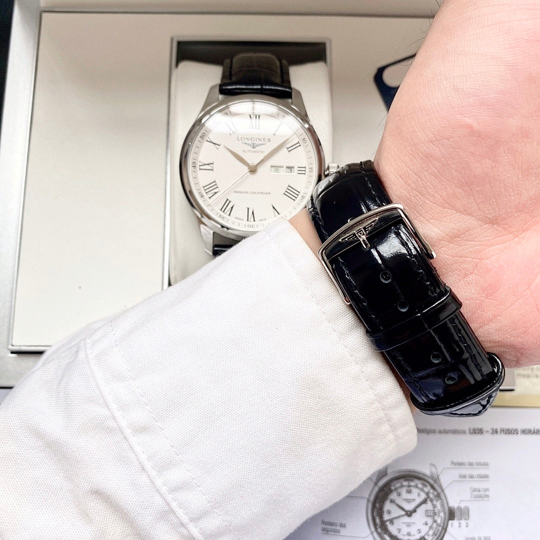 Automatic watch on wrist with white dial and black leather strap, crown visible