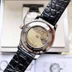Automatic watch with exposed movement, black leather strap and gold-toned case