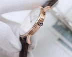 Longines watch case with rose-gold tone and crown, dark leather strap.
