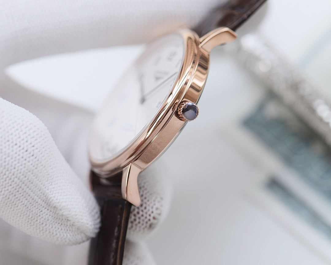 Longines watch case with rose-gold tone and crown, dark leather strap.