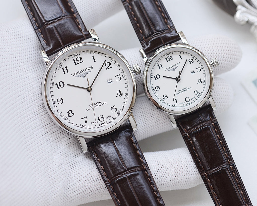 Longines watch set with silver-tone cases, white dials, brown leather straps.