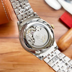 Longines watch caseback with visible mechanical movement and stainless link bracelet