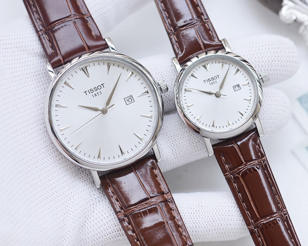 Two Tissot watches with brown leather straps and white round watch faces