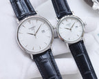 Two Tissot watches with dark blue leather straps and white round dials