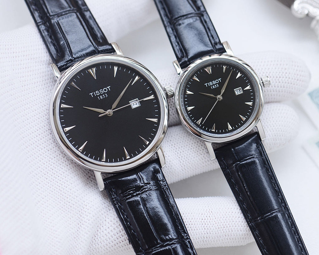 Two Tissot watches with black dials and dark blue leather straps