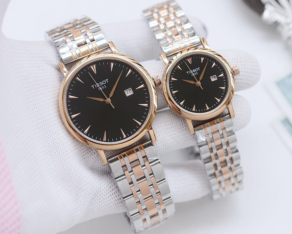 Two Tissot watches with dark dials and gold-tone cases on metal bracelets