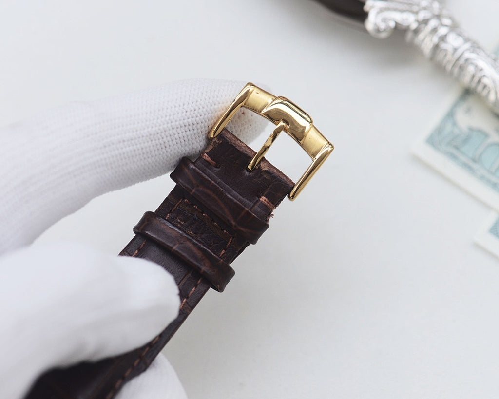 Leather watch strap with gold buckle clasp, dark brown crocodile-style pattern