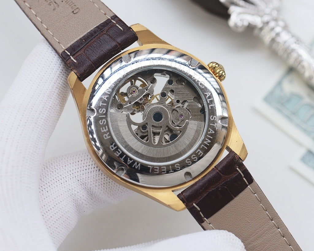 Skeleton analog watch with brown leather strap and gold case, visible mechanical movement