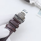 Longines wristwatch with brown leather strap and silver buckle, showing clasp underside.