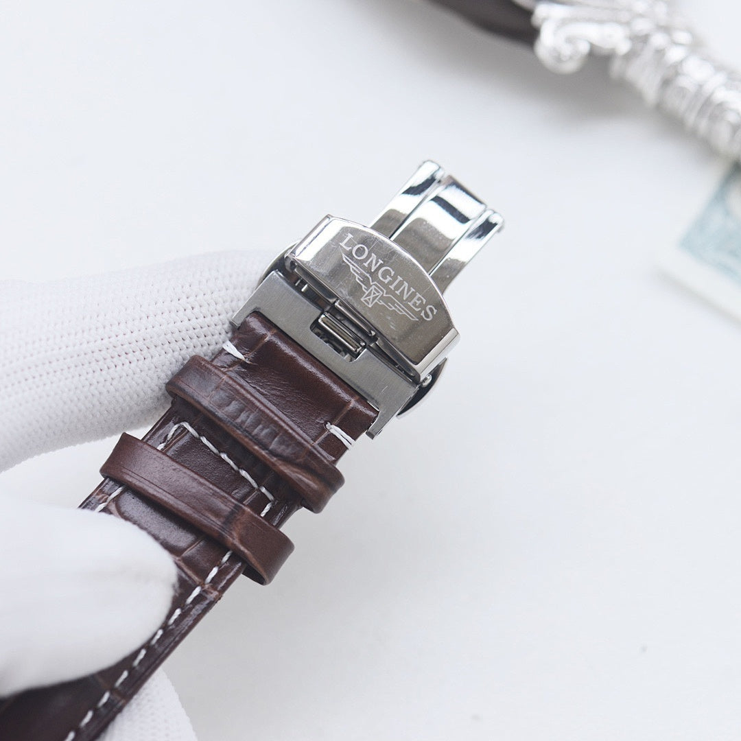 Longines wristwatch with brown leather strap and silver buckle, showing clasp underside.