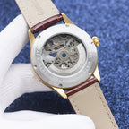 Longines watch case with exposed skeleton movement, brown leather strap, gold-tone bezel