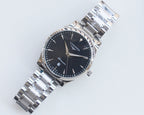 Longines watch with dark blue dial, silver metal bracelet and gold accents