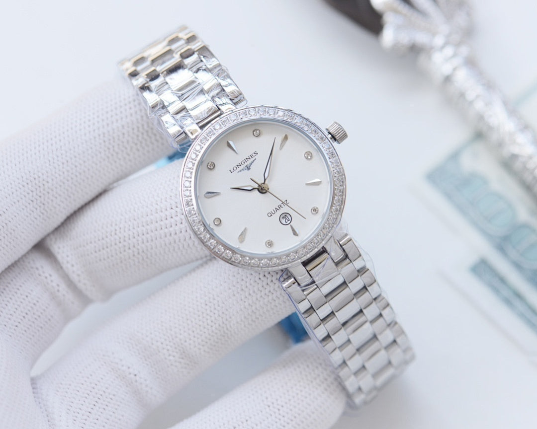 Longines watch with silver-toned case, sparkling bezel, and metal link bracelet, white dial