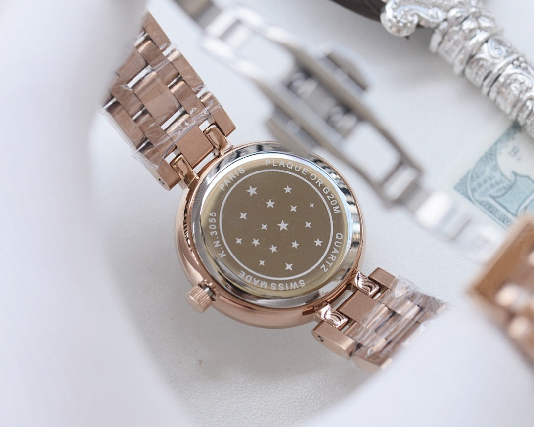 Longines watch with rose-gold case and metal bracelet, star-patterned case back visible