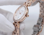Longines watch with rose-gold case, diamond-like bezel edge, and metal bracelet, white dial close-up