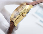 Gold-tone watch case side with engraved detailing and crown