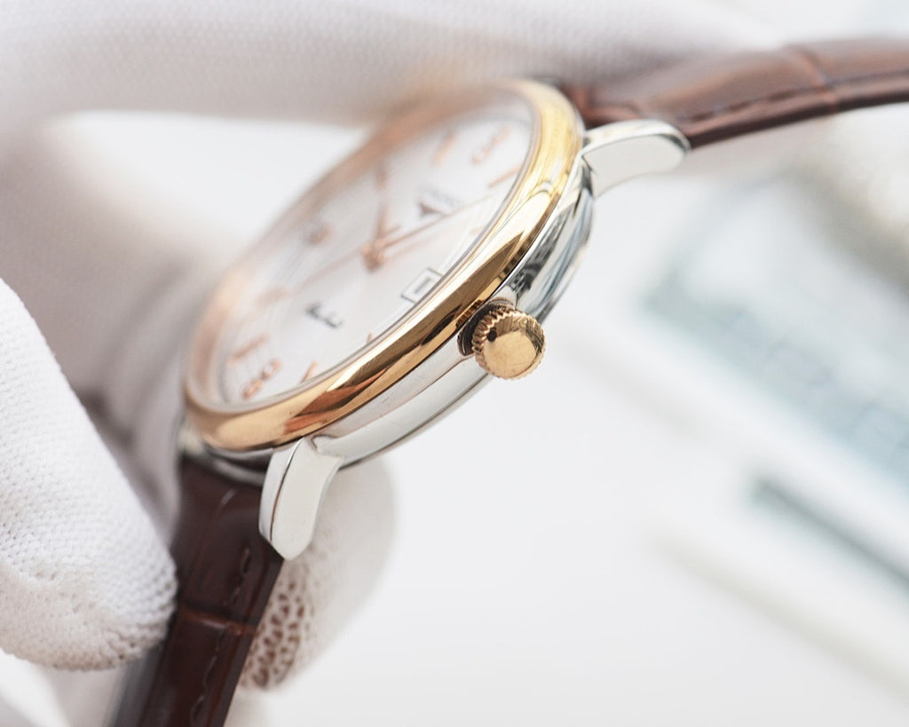 Gold-tone round watch with brown leather strap and crown detail