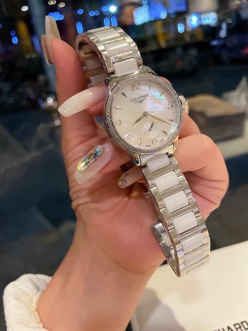 Longines stainless steel watch with silver bracelet and cream-white dial, held up close