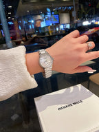 Longines stainless steel watch with silver bracelet and light dial on wrist