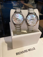 Longines stainless steel watch pair with silver bracelets and white dials on display
