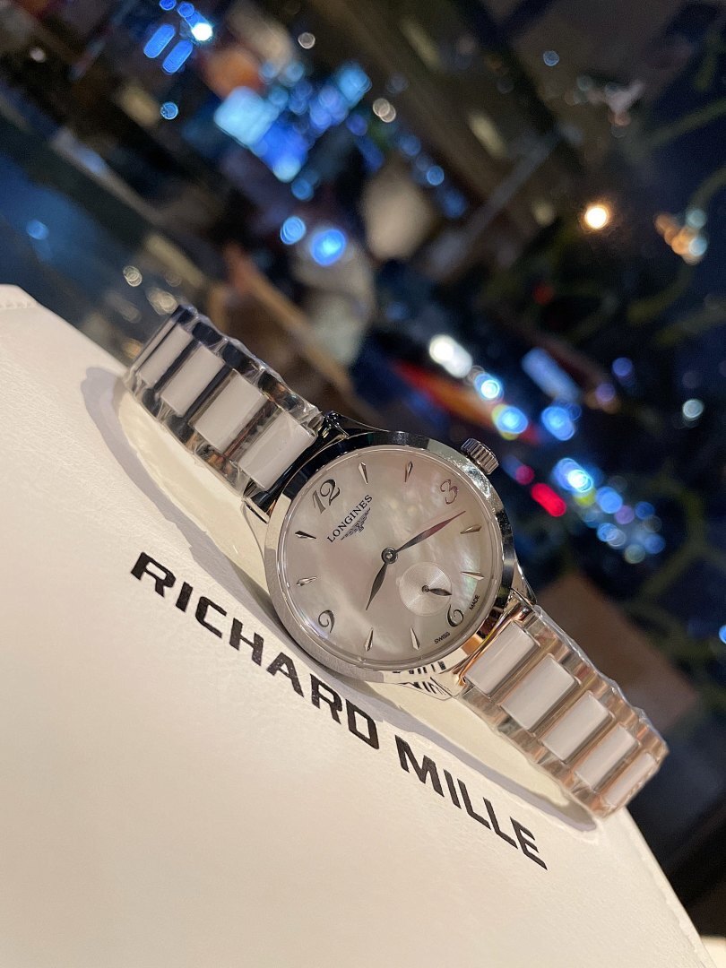 Longines stainless steel watch with silver bracelet and light dial, angled close-up